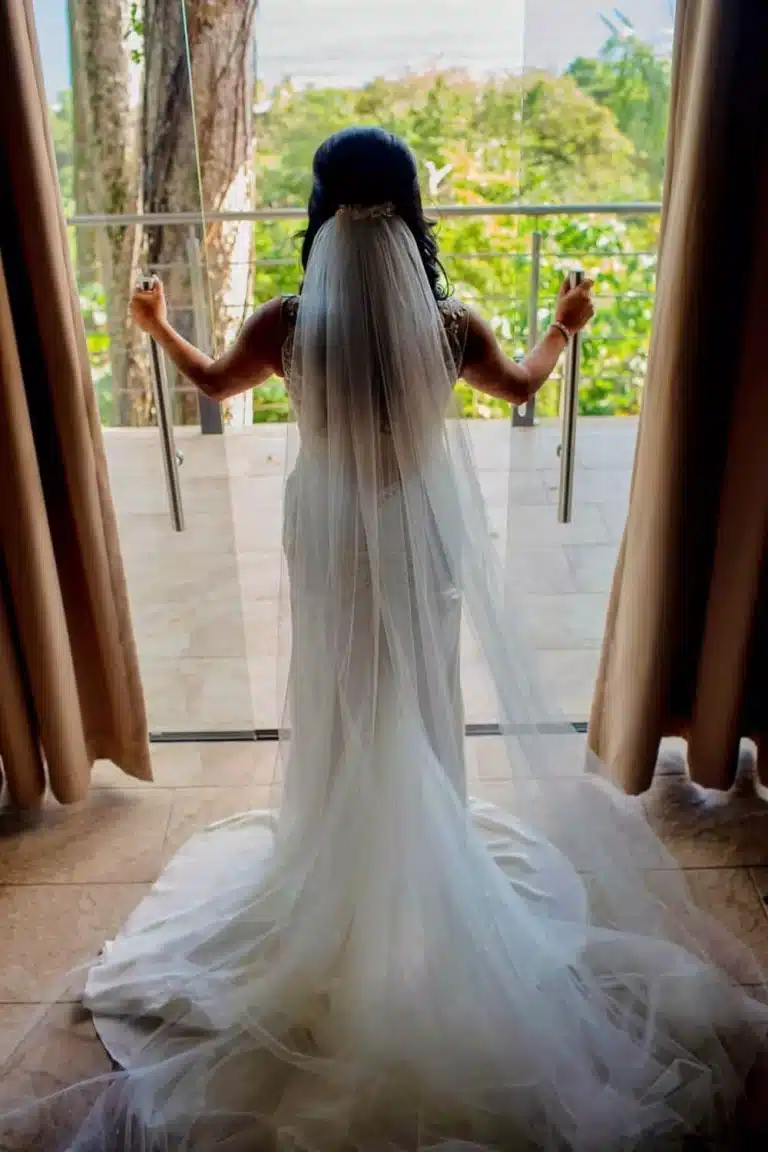 Costa Rica wedding bride standing in a luxury villa doorway, looking at lush jungle with exotic wildlife and Pacific Ocean