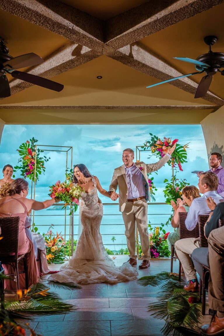 Costa Rica destination wedding ceremony with bride and groom celebrating joyfully at a tropical wedding venue overlooking the ocean