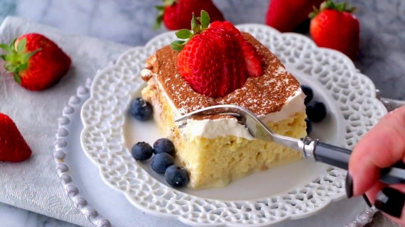 Tres leches sponge cake with whipped cream and strawberries
