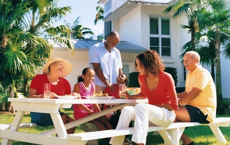 Vacation Rental Owner with Family Sitting Outdoors Enjoying a Meal