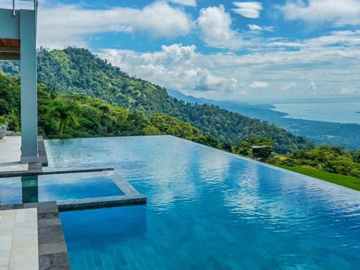 Infinity pool at Casa de Campo with ocean backdrop and tropical plants